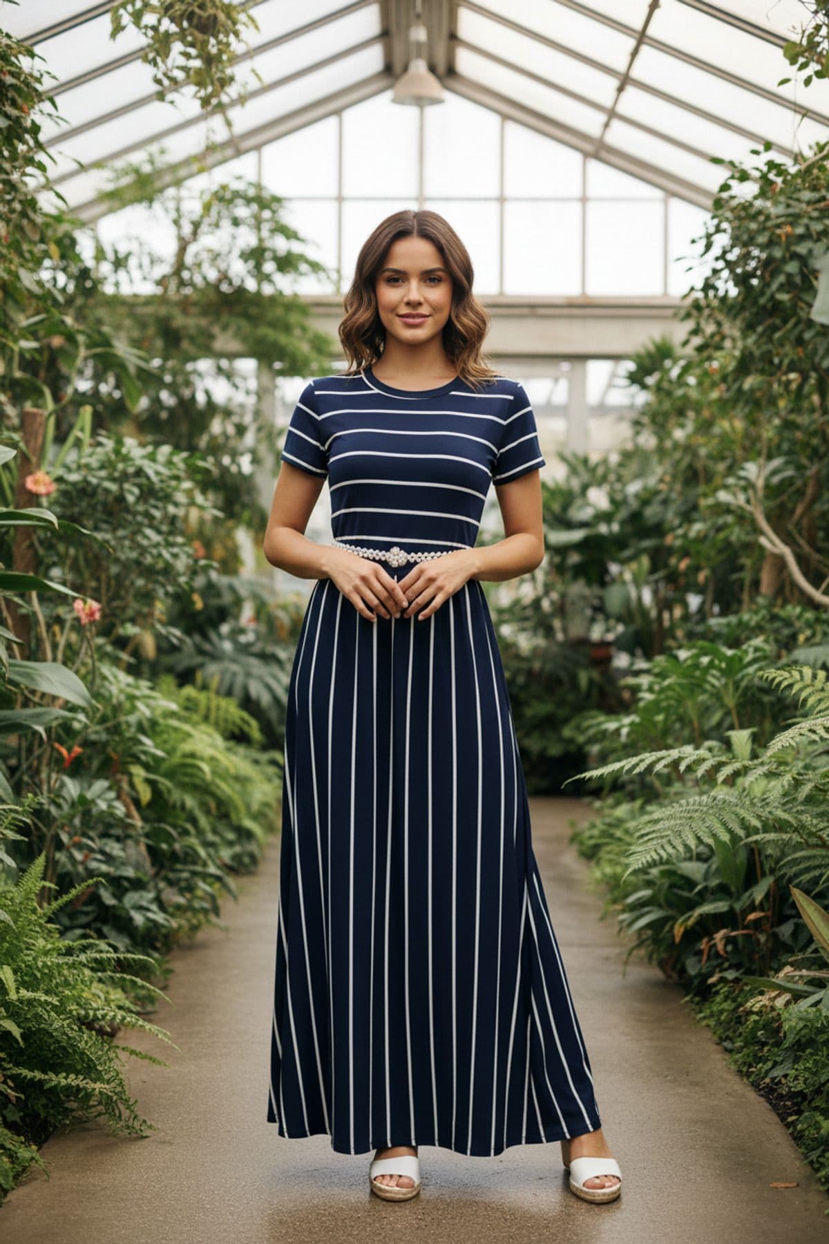 Woman wearing a navy blue maxi dress with white stripes and a pearl belt, perfect for a modest and stylish look.